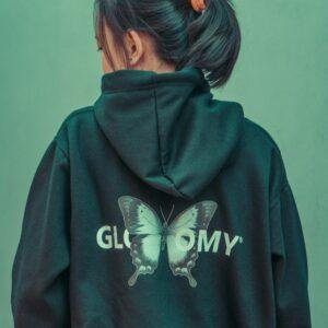 a woman wearing a green hoodie with a butterfly on it